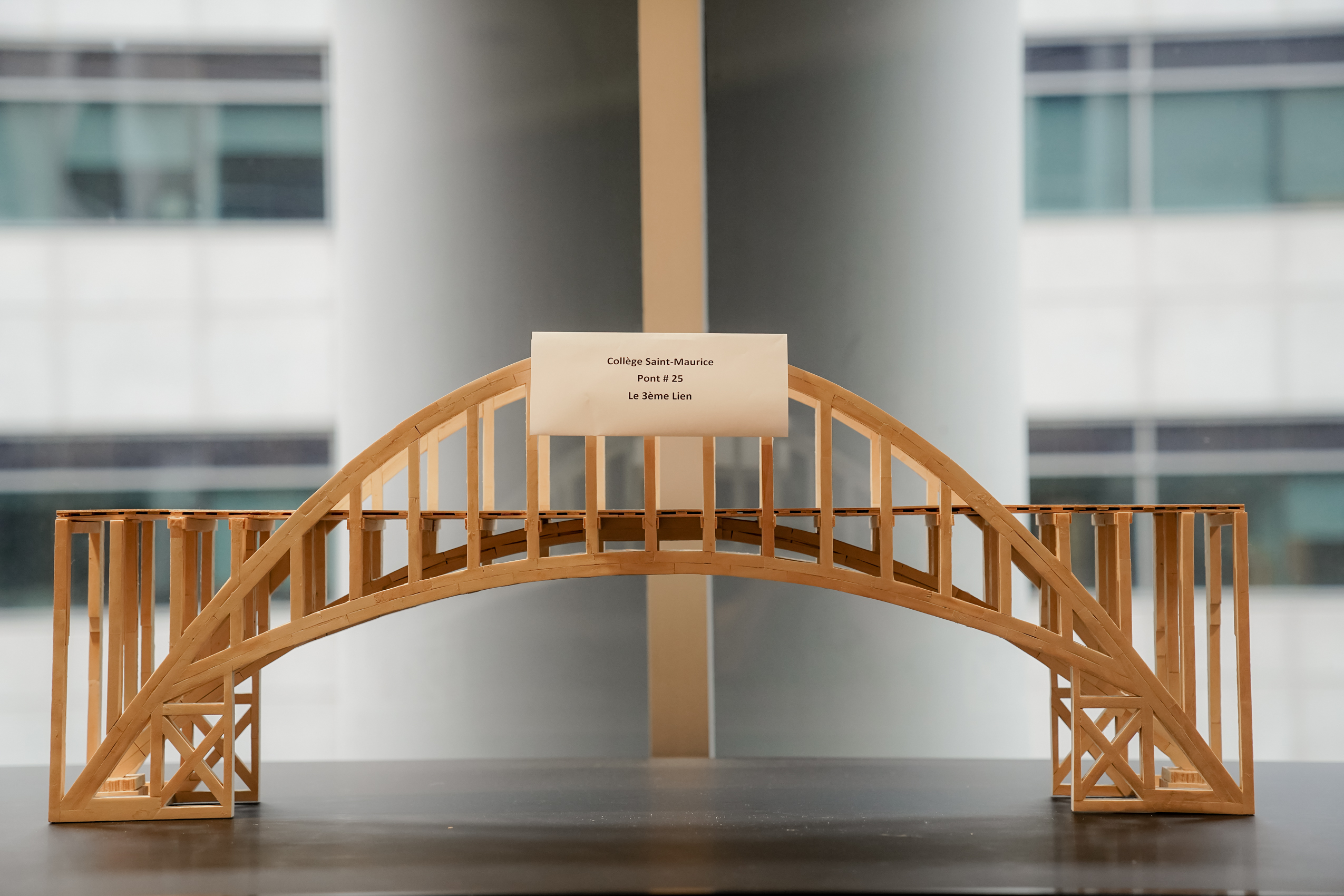 Maquette de pont en bois affichée par le Collège Saint-Maurice, nommée "Pont #25, Le 3ème Lien".