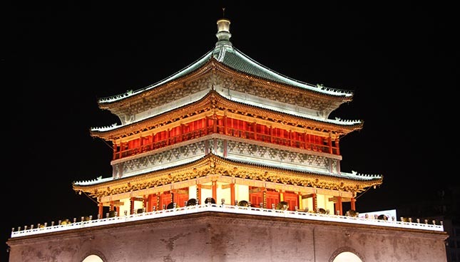 Illuminated traditional Chinese architecture at night, reflecting technological heritage and innovation.