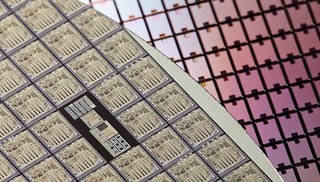 Close-up of a semiconductor wafer, showcasing microchip patterns.