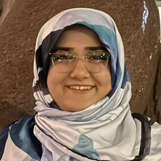 "Smiling student with hijab, showcasing diversity and inclusion in higher education technology."