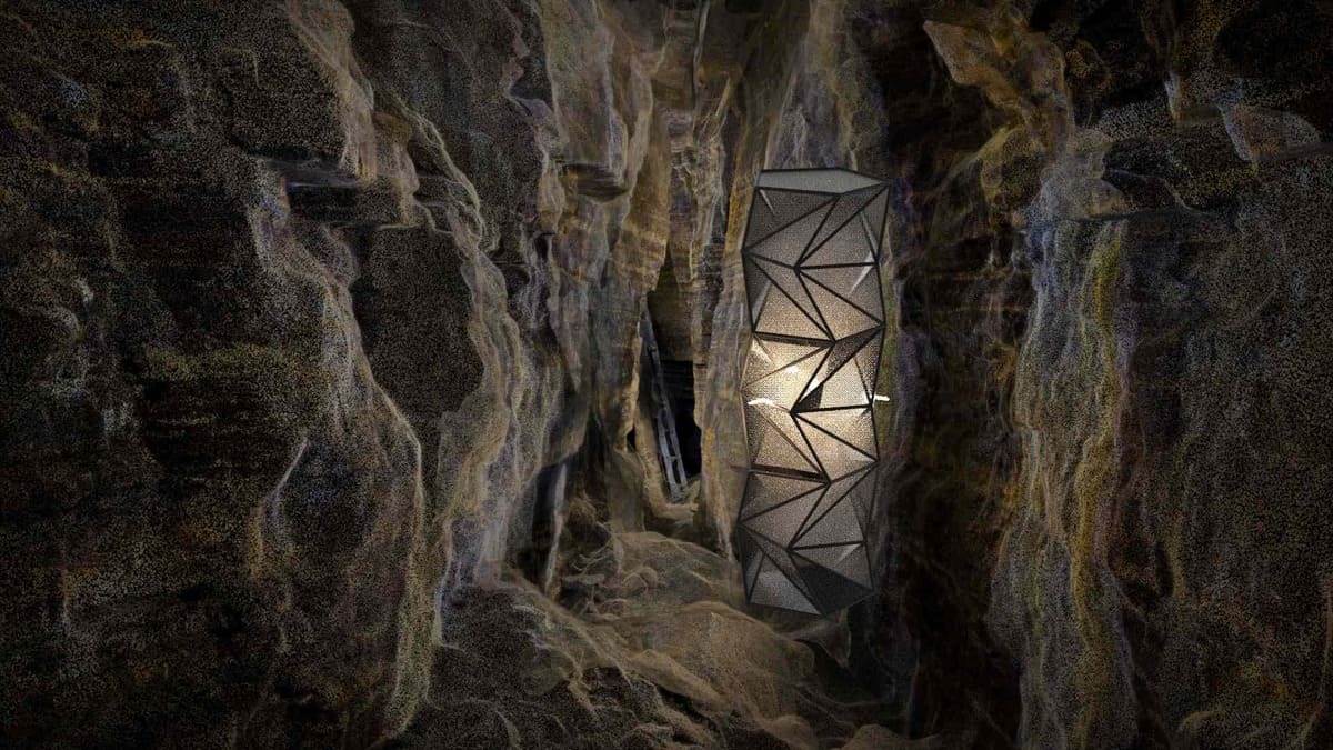 Modern geometric light fixture nestled within rugged rock walls, showcasing a fusion of nature and design.