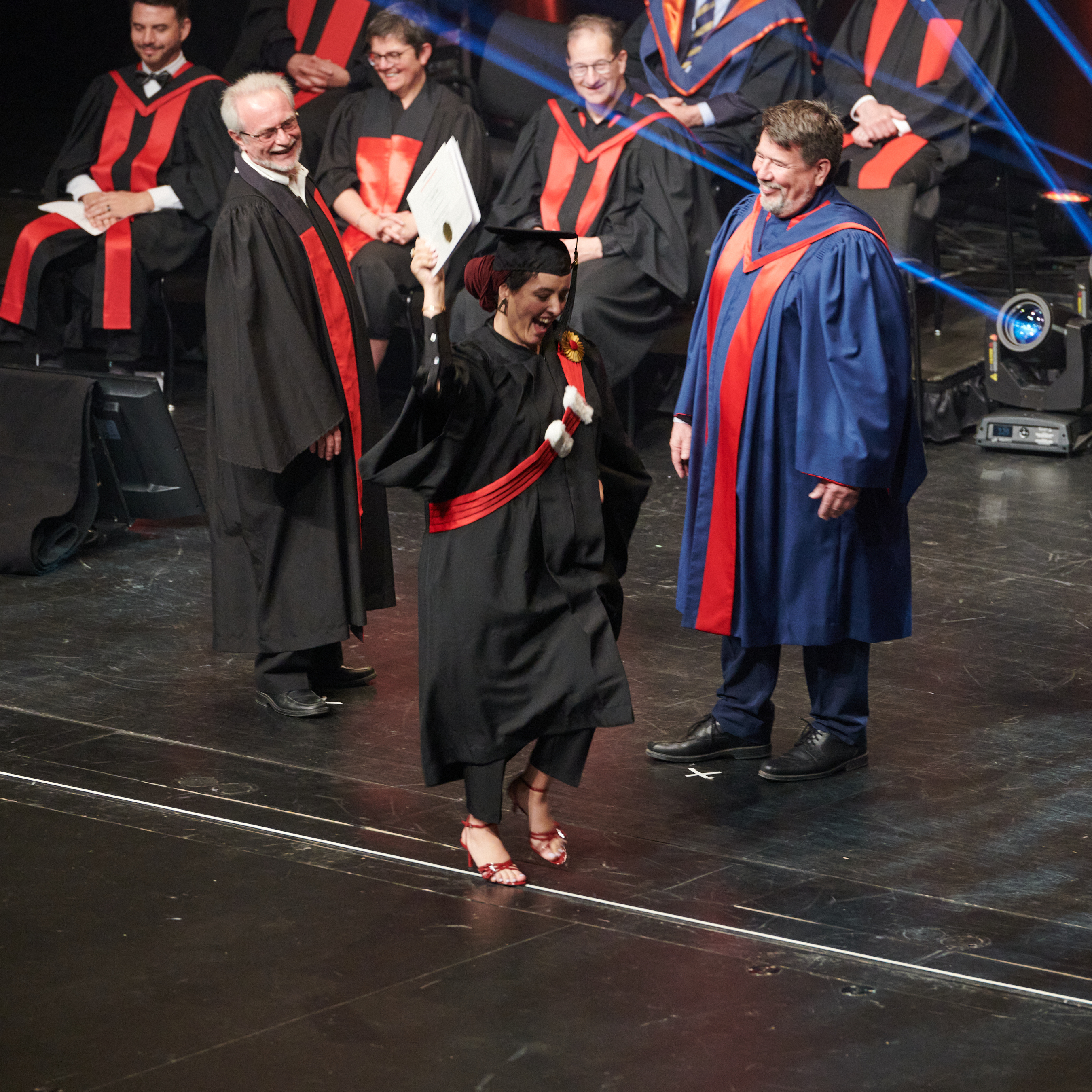 Étudiante souriante reçoit son diplôme lors d'une cérémonie de remise de grades.