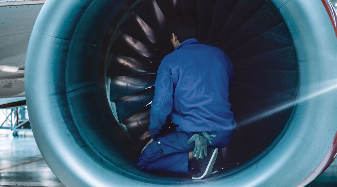 A technician works on a jet engine, showcasing advanced aerospace engineering.