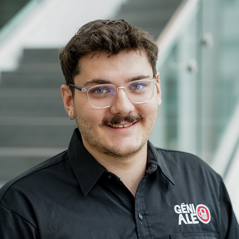 Étudiant souriant en génie, portant un polo avec le logo de son département.