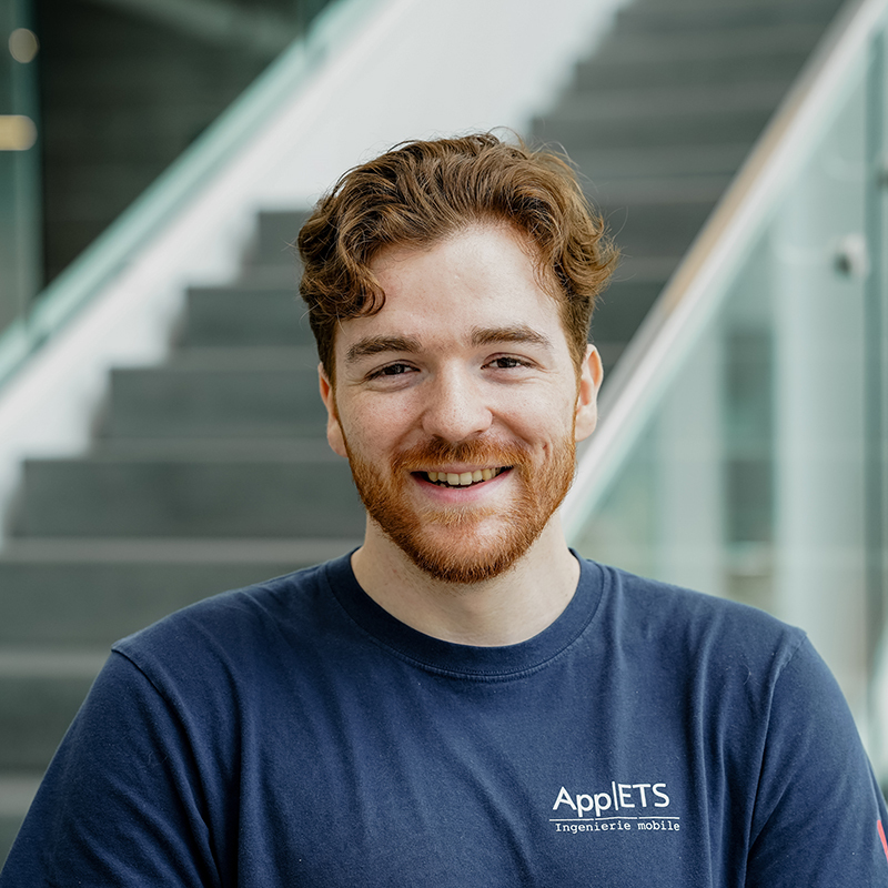 Étudiant souriant avec logo d'ingénierie, évoquant innovation et avenir en technologie.