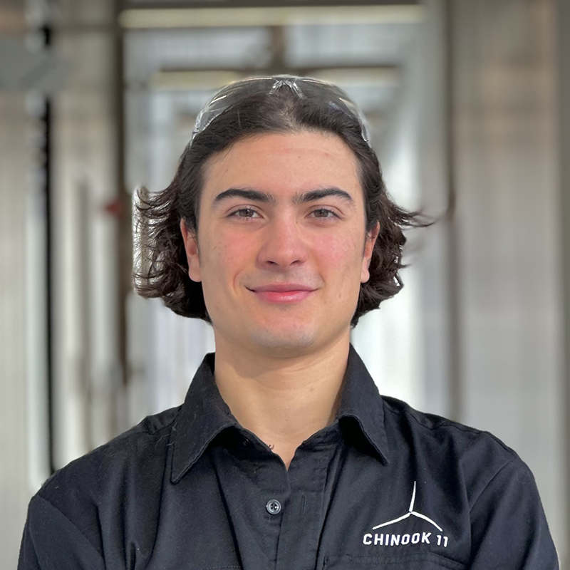 Étudiant en technologie souriant avec un polo "CHINOOK 11".