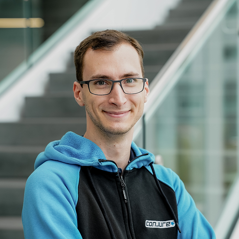 Étudiant souriant en sweat à capuche, incarnant la jeunesse et l'innovation technologique.