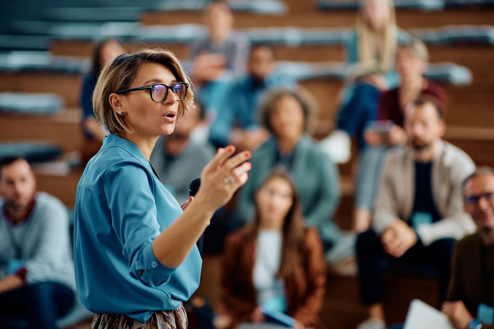 Intervenante dynamique partageant son expertise avec un groupe d'étudiants attentifs.