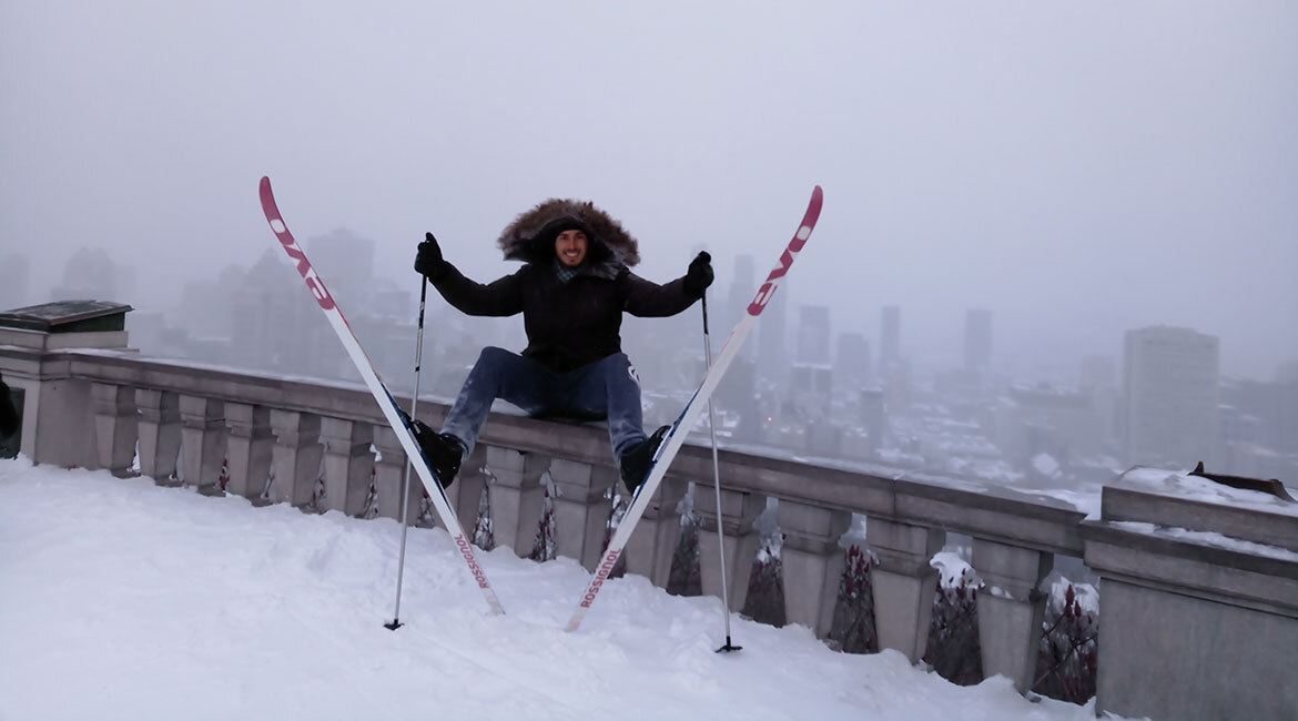 Student enjoys urban skiing adventure amidst a snowy cityscape.