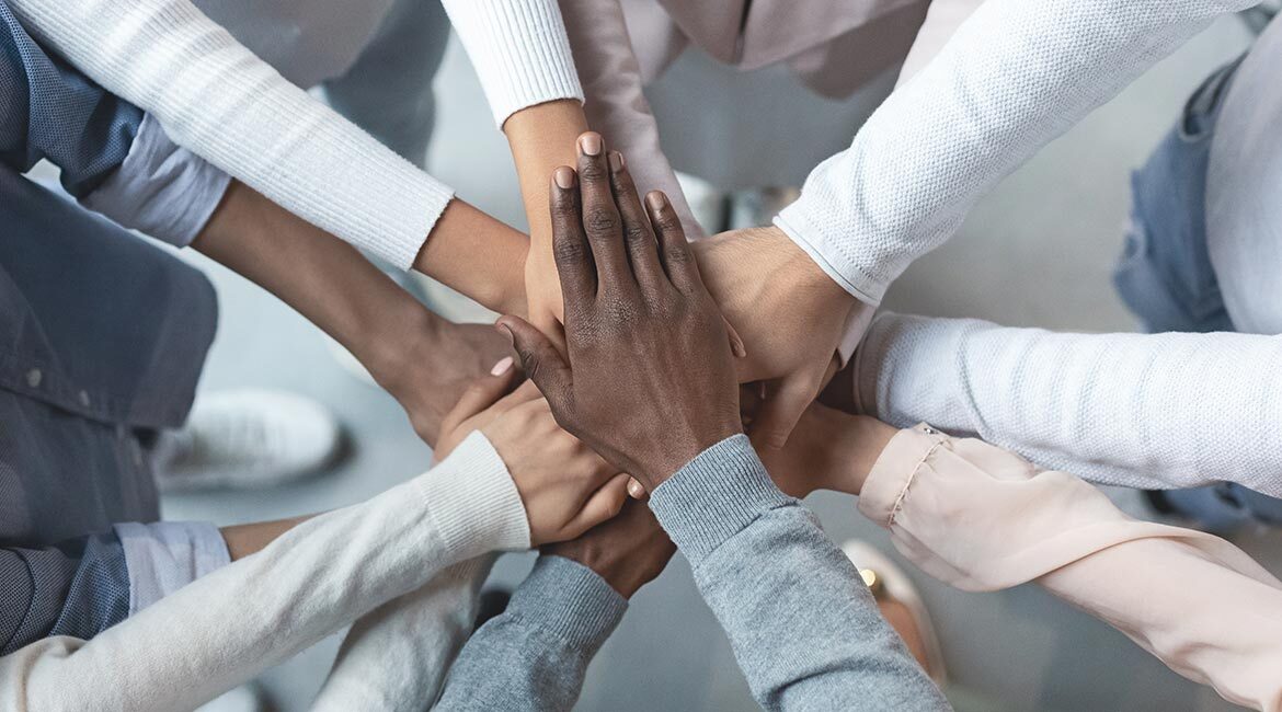Diverse team unites hands, symbolizing collaboration and unity.