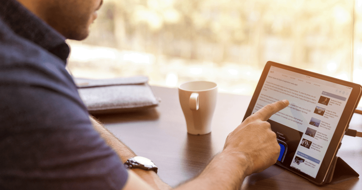 Student consulting a tablet for education with a cup of coffee.