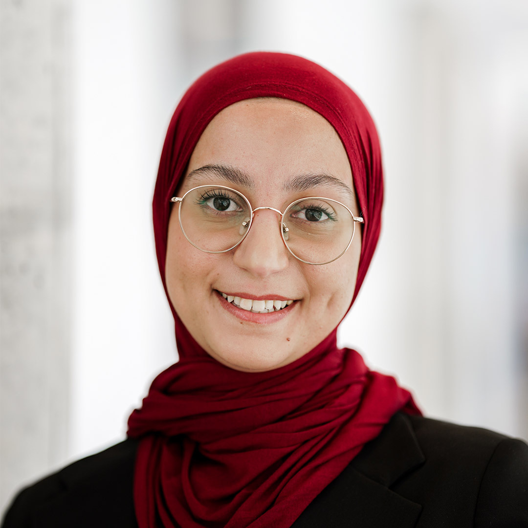 Étudiante souriante en hijab et lunettes, représentant la diversité en éducation.