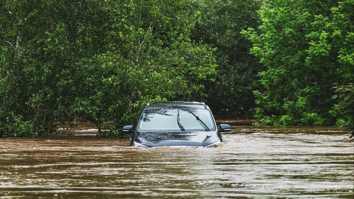 Véhicule submergé lors d'une inondation, illustrant les défis des changements climatiques.